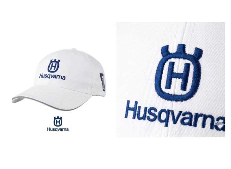 Zbliżenie na wypukły, trójwymiarowy haft logo Husqvarna na białej czapce. Precyzyjne znakowanie odzieży.