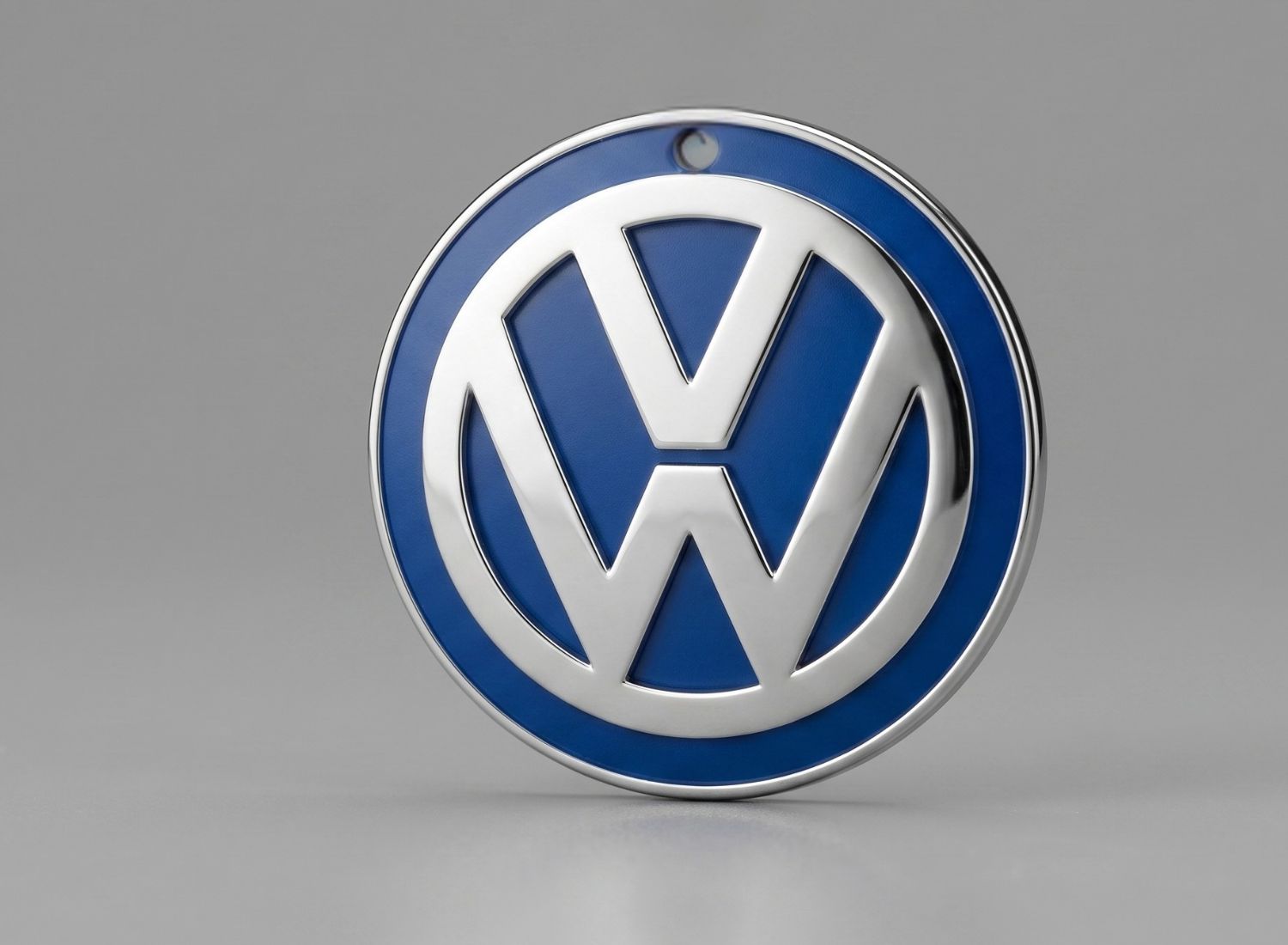 Okrągła zawieszka zapachowa do samochodu z niebieskim logo Volkswagen. Gadżety reklamowe dla dealerów samochodowych.
