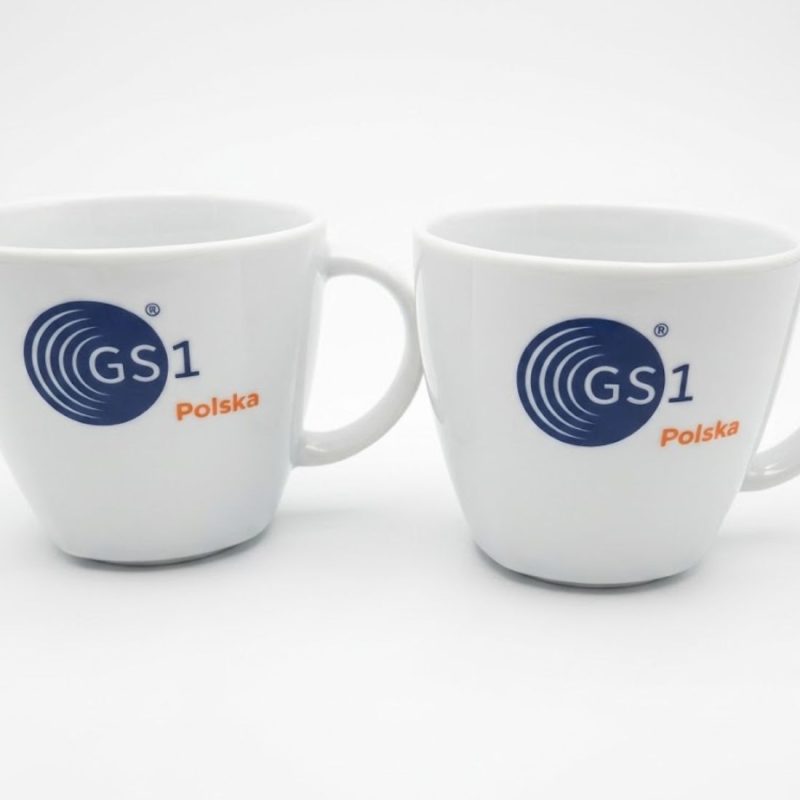 Dwie białe filiżanki biurowe z kolorowym nadrukiem logo GS1 Polska. Klasyczna ceramika reklamowa dla firm.